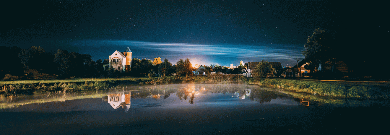Unter Nachtwolken am Flusssee steigt ein Flüstern auf, das uralte Geheimnisse in den Sternen offenbart.